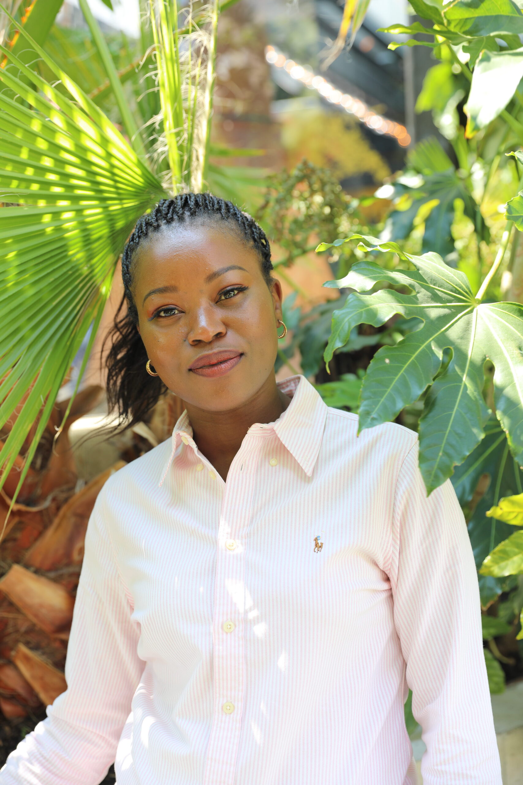 Image of Winnie Akadjo in a pink and white stripped Ralph Lauren shirt.